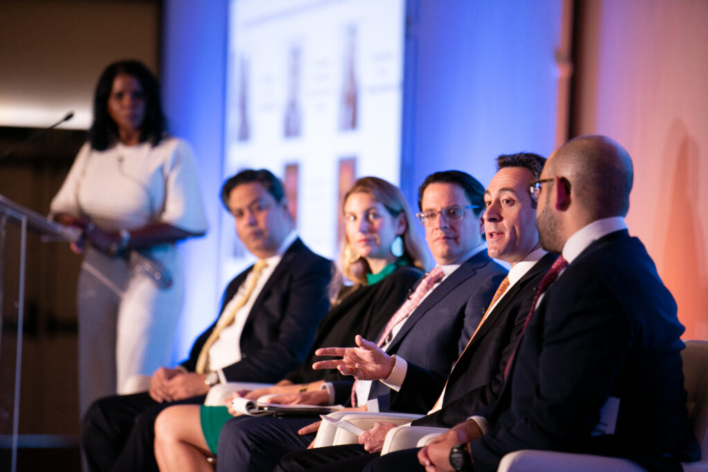 A presentation held by 5 people, while a moderator looks on.