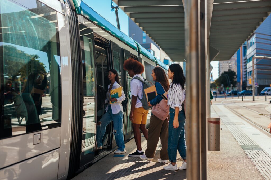 A group of university students going home after classes at school are entering the public transportation train.